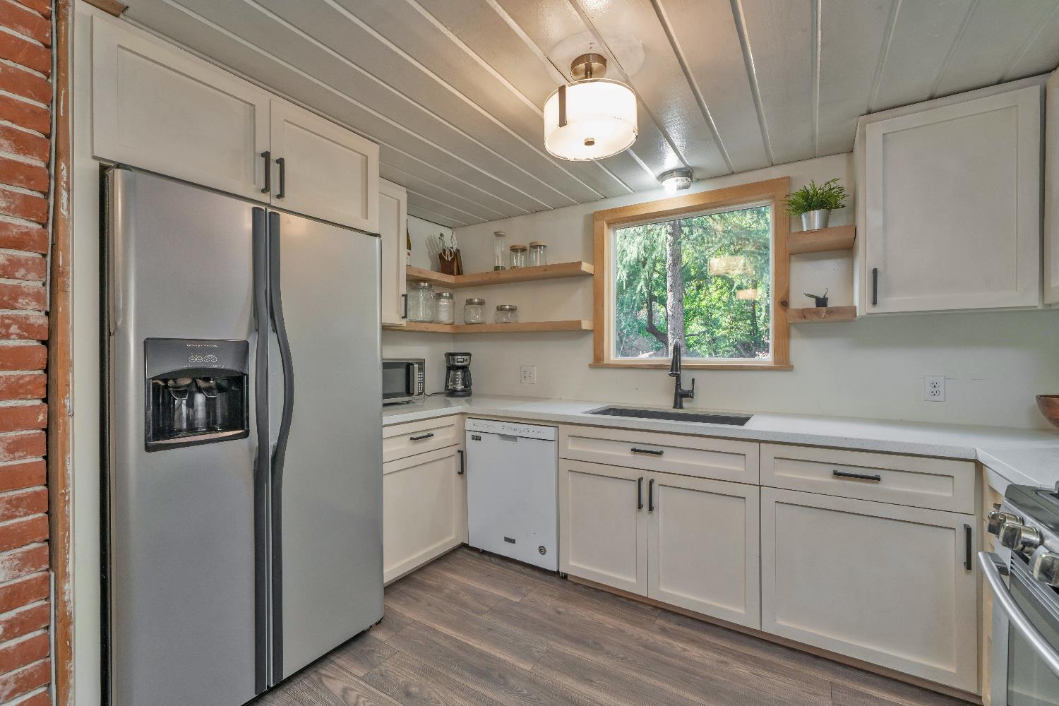 5921 Bear Creek Road Garden Valley, CA 95633 - Photo 14 of 55 a kitchen with white cabinets and window
