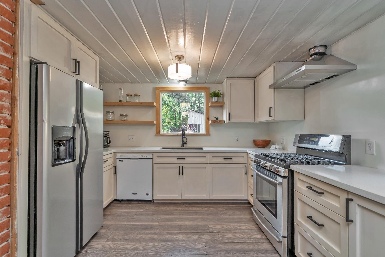 5921 Bear Creek Road Garden Valley, CA 95633 - Photo 3 of 55 a kitchen with stainless steel appliances a refrigerator a stove a sink and white cabinets