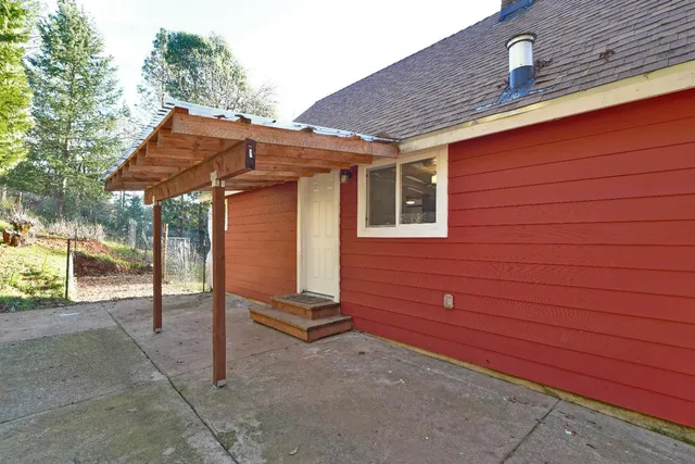 a view of a backyard with chairs and table