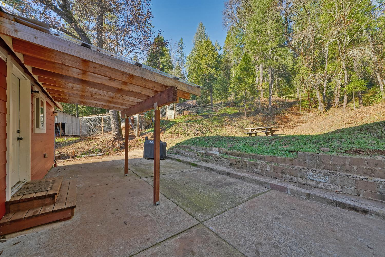 5921 Bear Creek Road Garden Valley, CA 95633 - Photo 46 of 55 a view of a patio with table and chairs and a tree