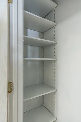 a view of walk in closet with empty racks