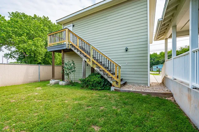 a view of a house with a yard and a wooden deck