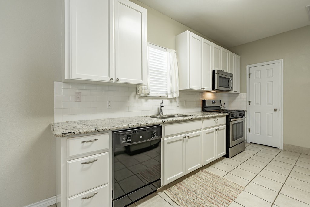 6007 Fairway Street, Unit C Austin, TX 78741 - Photo 9 of 22 a kitchen with stainless steel appliances granite countertop a stove a sink and a microwave