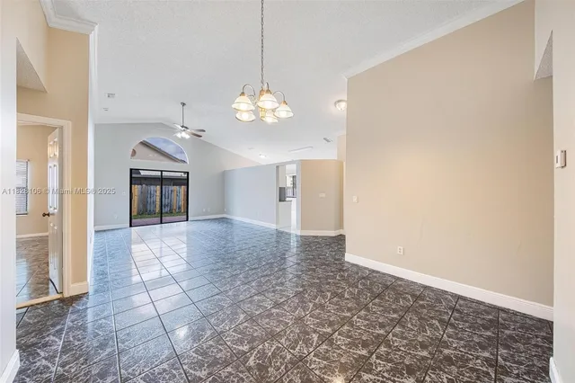 a view of a hallway with wooden floor and chandelier