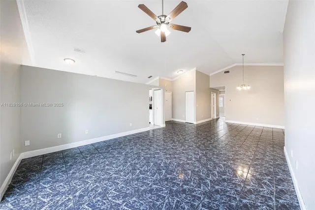a view of a livingroom with a ceiling fan and kitchen view