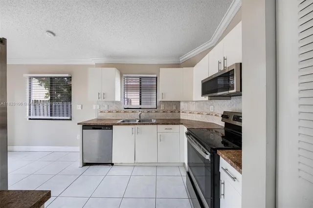 a kitchen with a sink stove and cabinets