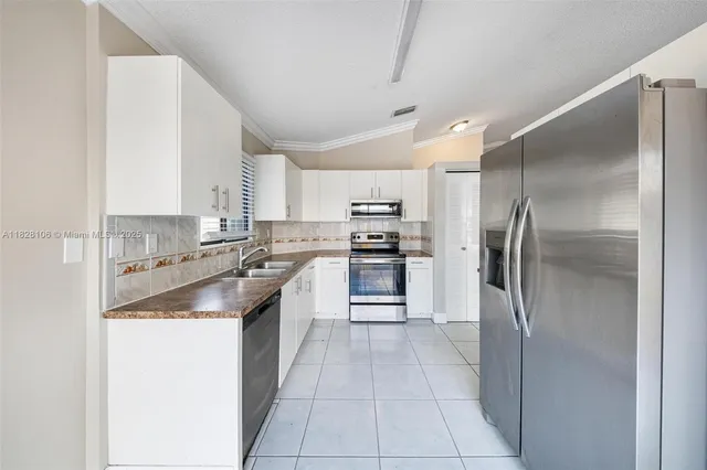 a kitchen with stainless steel appliances granite countertop a refrigerator and a sink