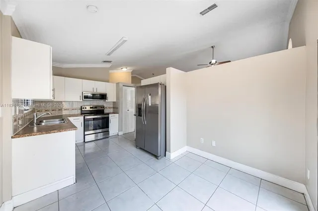 a kitchen with granite countertop a refrigerator and a stove top oven