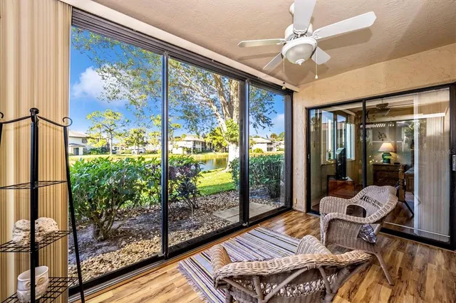 a view of a brick house with large windows and flower plants