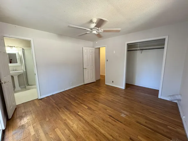 a view of a big room with wooden floor and windows