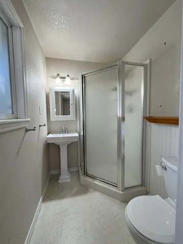 a bathroom with a toilet a sink and mirror