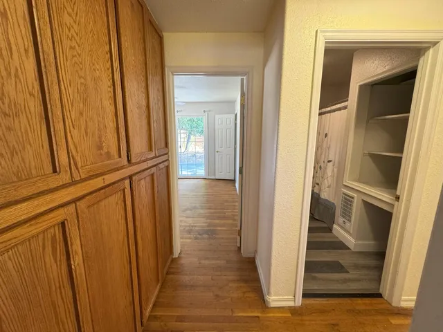 a view of a hallway with wooden floor and staircase
