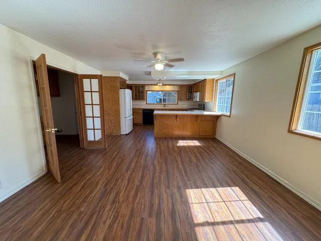 a view of a living room with wooden floor and a window