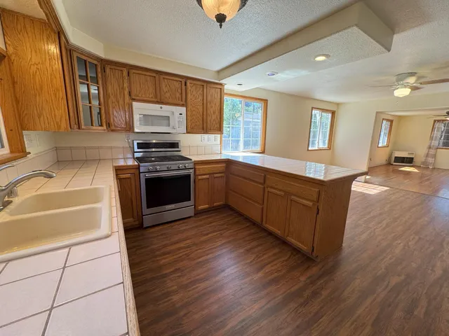 a kitchen with stainless steel appliances granite countertop a stove a sink and a refrigerator