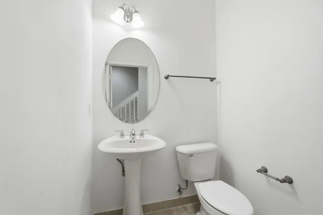 a bathroom with a toilet sink and mirror