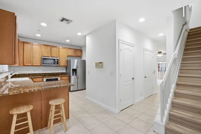 a kitchen with stainless steel appliances granite countertop a refrigerator and a stove top oven