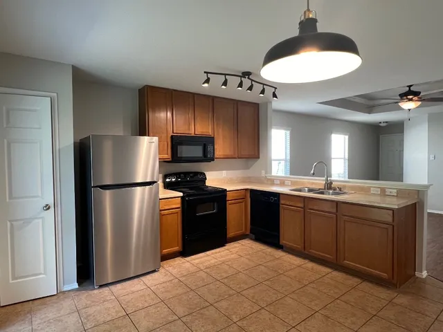 a kitchen with stainless steel appliances granite countertop a refrigerator a sink a stove a microwave and island