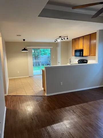 a view of a kitchen with wooden floor and a window