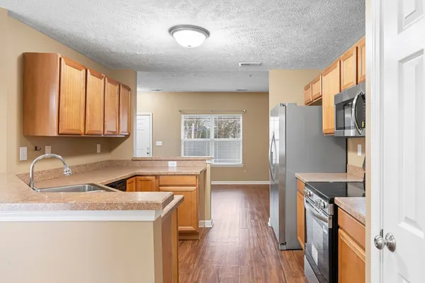 a kitchen with stainless steel appliances granite countertop a sink stove and refrigerator