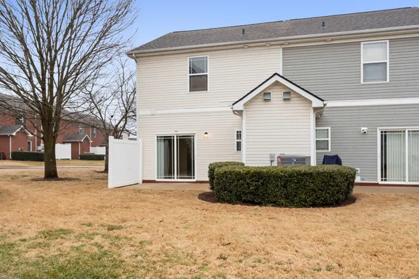 a view of a house with a yard and large tree