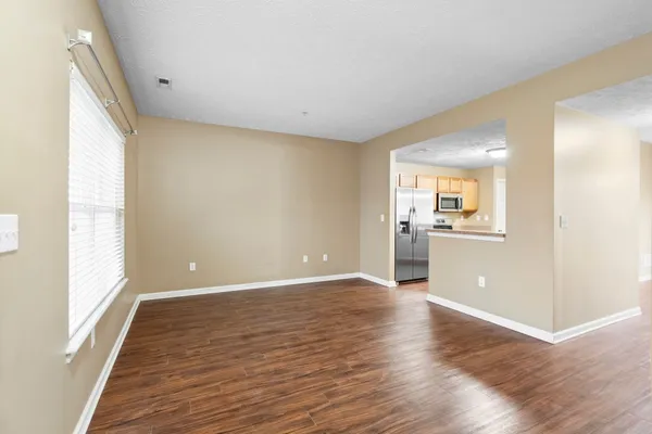 a view of a big room with wooden floor and windows