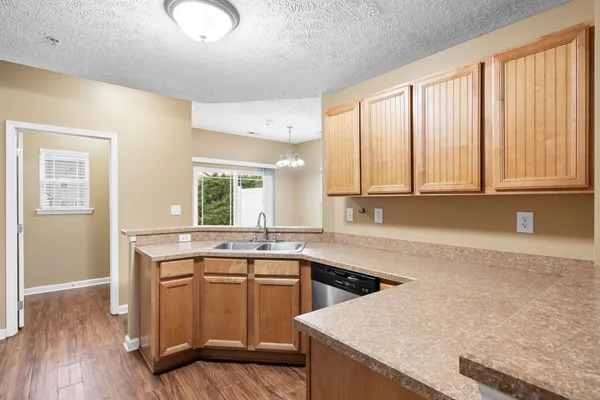 a kitchen with a sink a stove cabinets and wooden floor