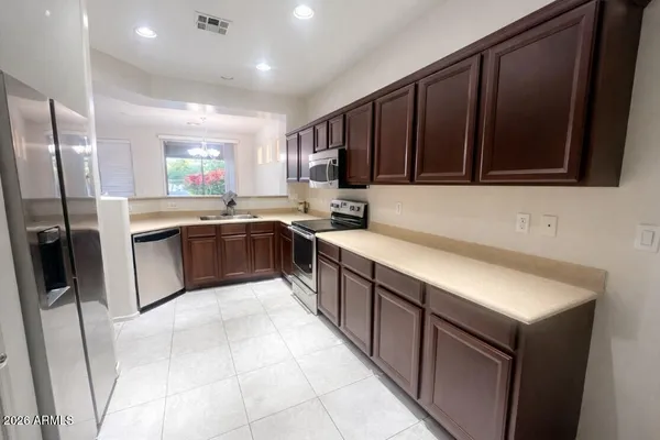 a kitchen with stainless steel appliances granite countertop a sink stove and refrigerator