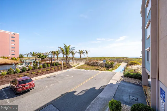 a tall building with a large window and potted plants