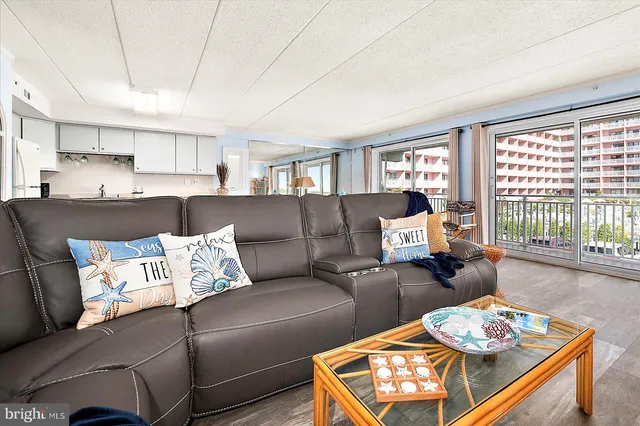 a living room with furniture and a floor to ceiling window