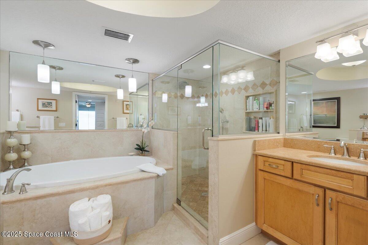 2375 South Atlantic Avenue, Unit 302 Cocoa Beach, FL 32931 - Photo 15 of 36 a bathroom with a granite countertop sink mirror and a bathtub