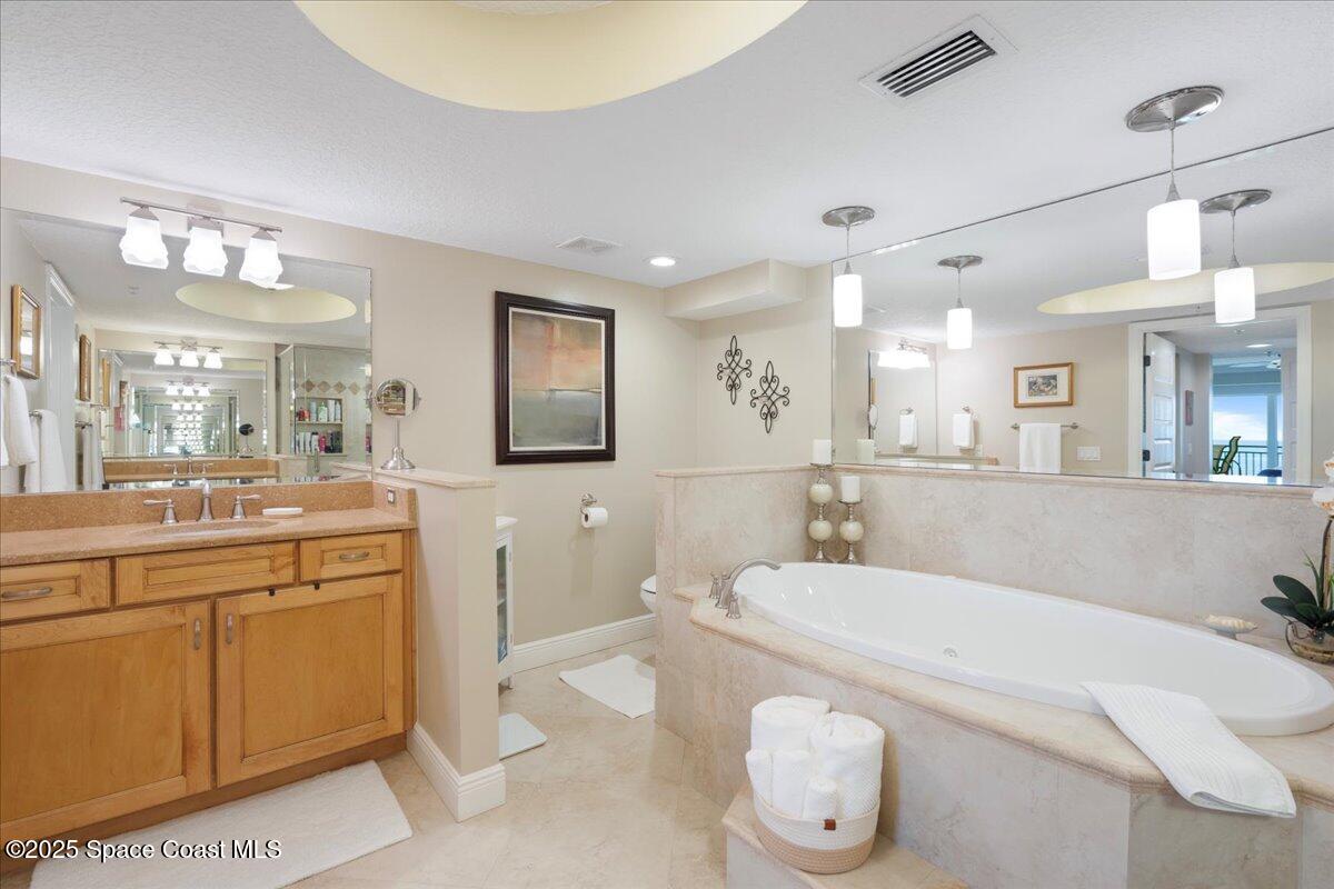 2375 South Atlantic Avenue, Unit 302 Cocoa Beach, FL 32931 - Photo 16 of 36 a spacious bathroom with a tub sink and mirror