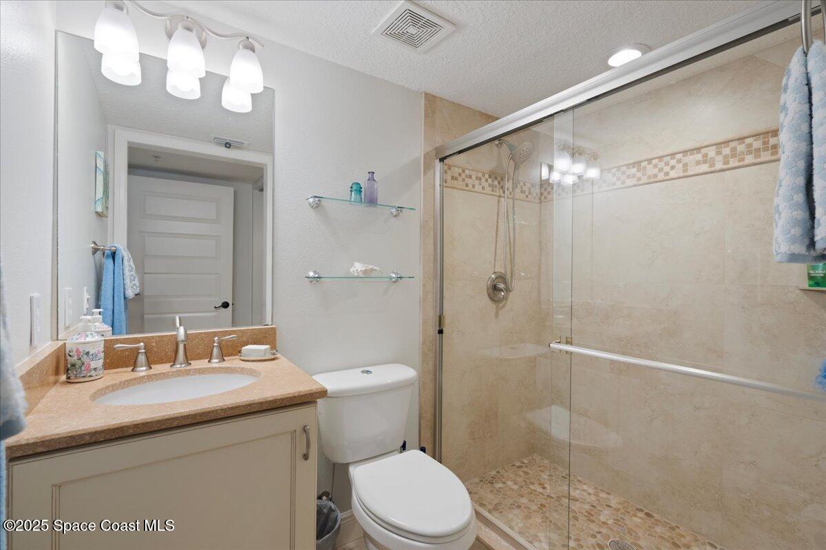 2375 South Atlantic Avenue, Unit 302 Cocoa Beach, FL 32931 - Photo 19 of 36 a bathroom with a granite countertop sink toilet and shower