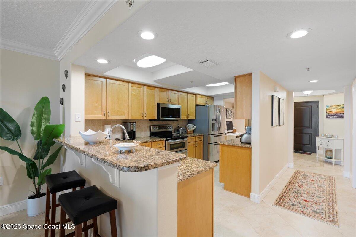 2375 South Atlantic Avenue, Unit 302 Cocoa Beach, FL 32931 - Photo 8 of 36 a kitchen with stainless steel appliances granite countertop sink stove refrigerator and cabinets