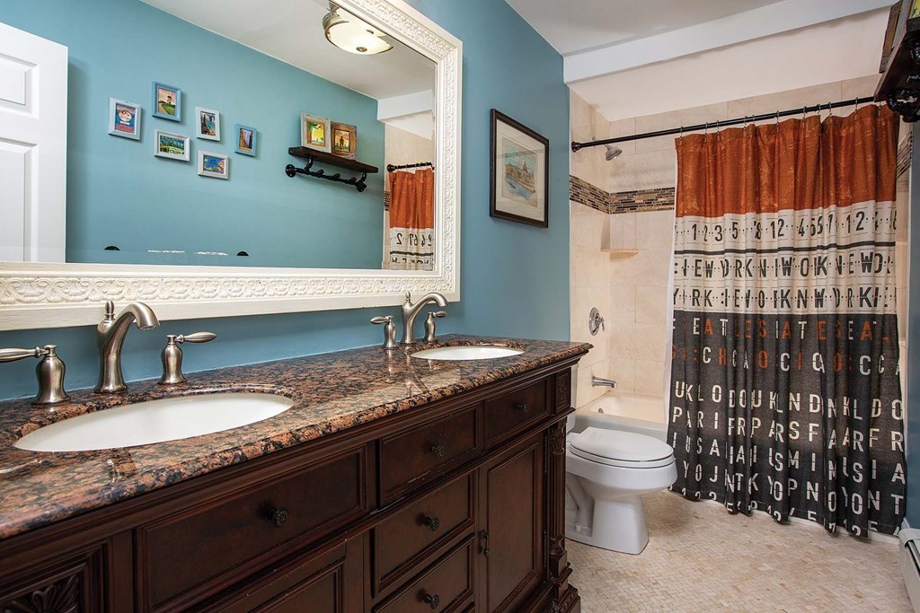 140 Kilsyth Road, Unit 4 Boston, MA 02135 - Photo 8 of 9 a bathroom with a granite countertop sink a toilet and a mirror