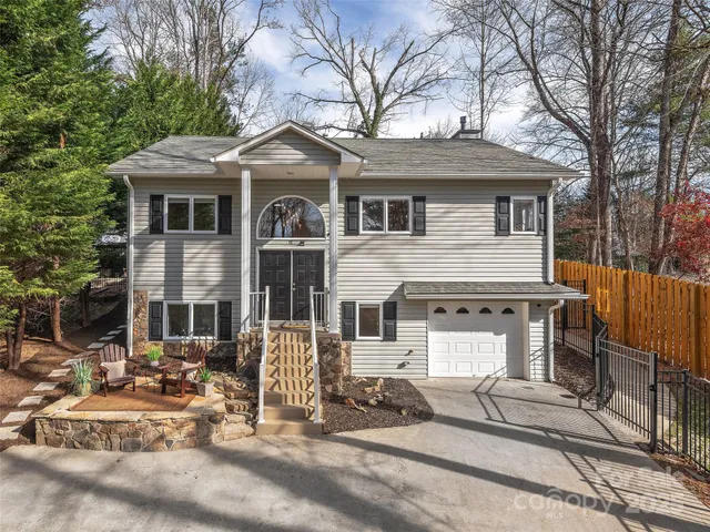 a front view of a house with yard and trees