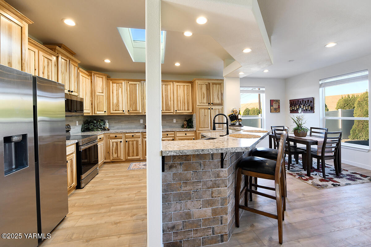 200 Bridle Way, Unit 129 Yakima, WA 98901 - Photo 11 of 20 a kitchen with stainless steel appliances kitchen island granite countertop a stove a sink a oven a dining table and chairs