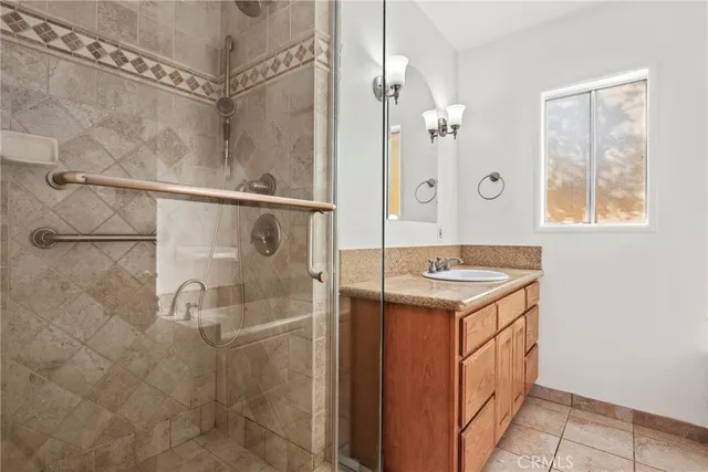 a bathroom with a granite countertop shower sink and mirror
