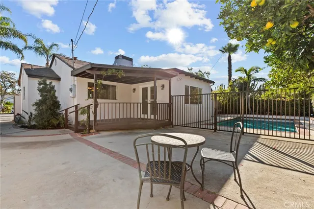 a view of a patio with a table and chairs with wooden fence
