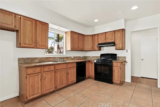 a kitchen with stainless steel appliances granite countertop a stove sink and cabinets