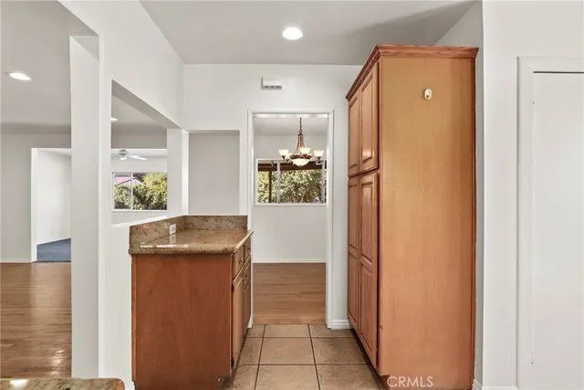 a view of a hallway with windows and refrigerator