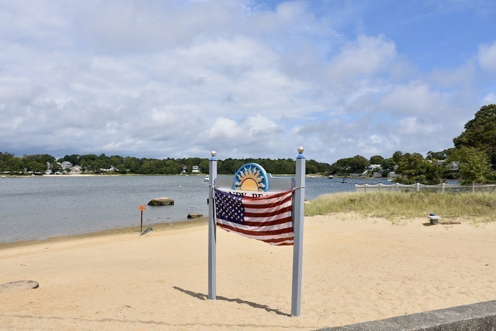 4 Wellington Road Wareham, MA 02558 - Photo 30 of 35 a view of a lake with a bench in front of house