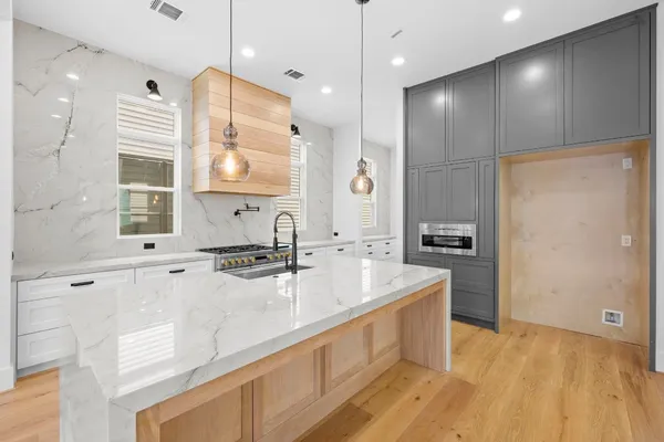 a large kitchen with kitchen island a sink stainless steel appliances and cabinets