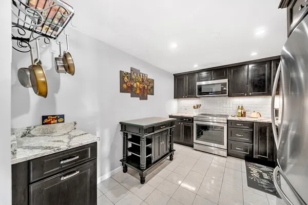 a kitchen with stainless steel appliances a stove microwave and sink