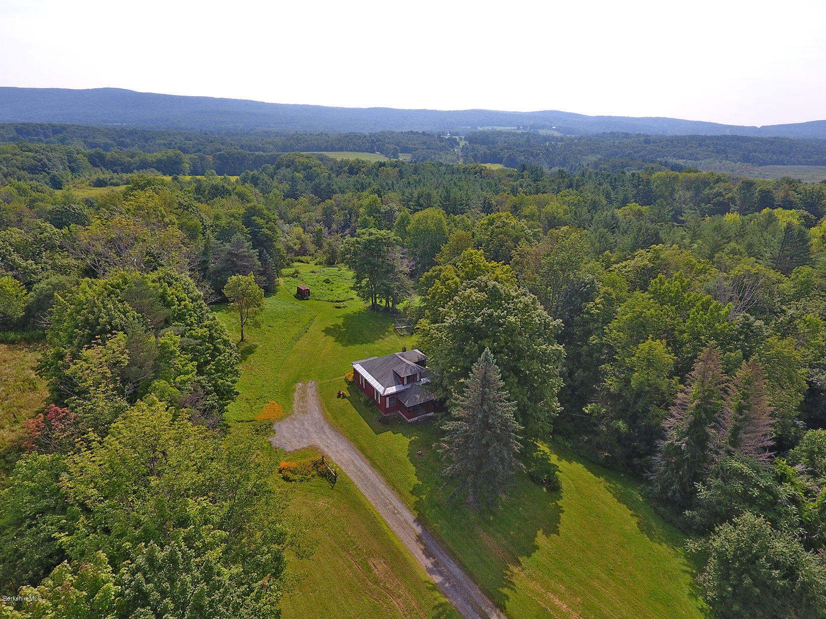 1455 State Road Richmond, MA 01254 - Photo 3 of 15 a view of a lush green hillside and a houses