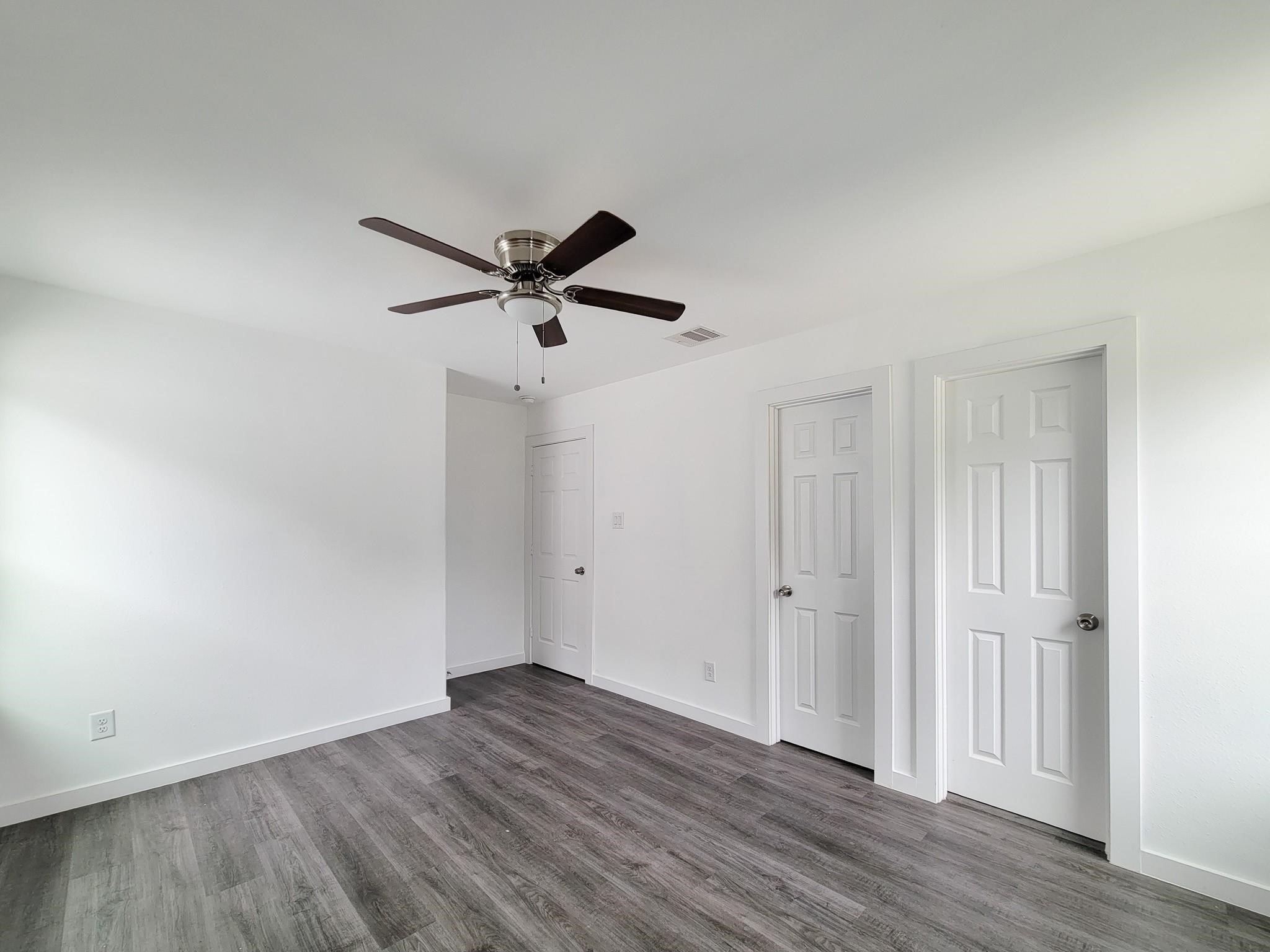 8122 Sterlingshire Street, Unit B Houston, TX 77078 - Photo 18 of 27 an empty room with wooden floor and a ceiling fan