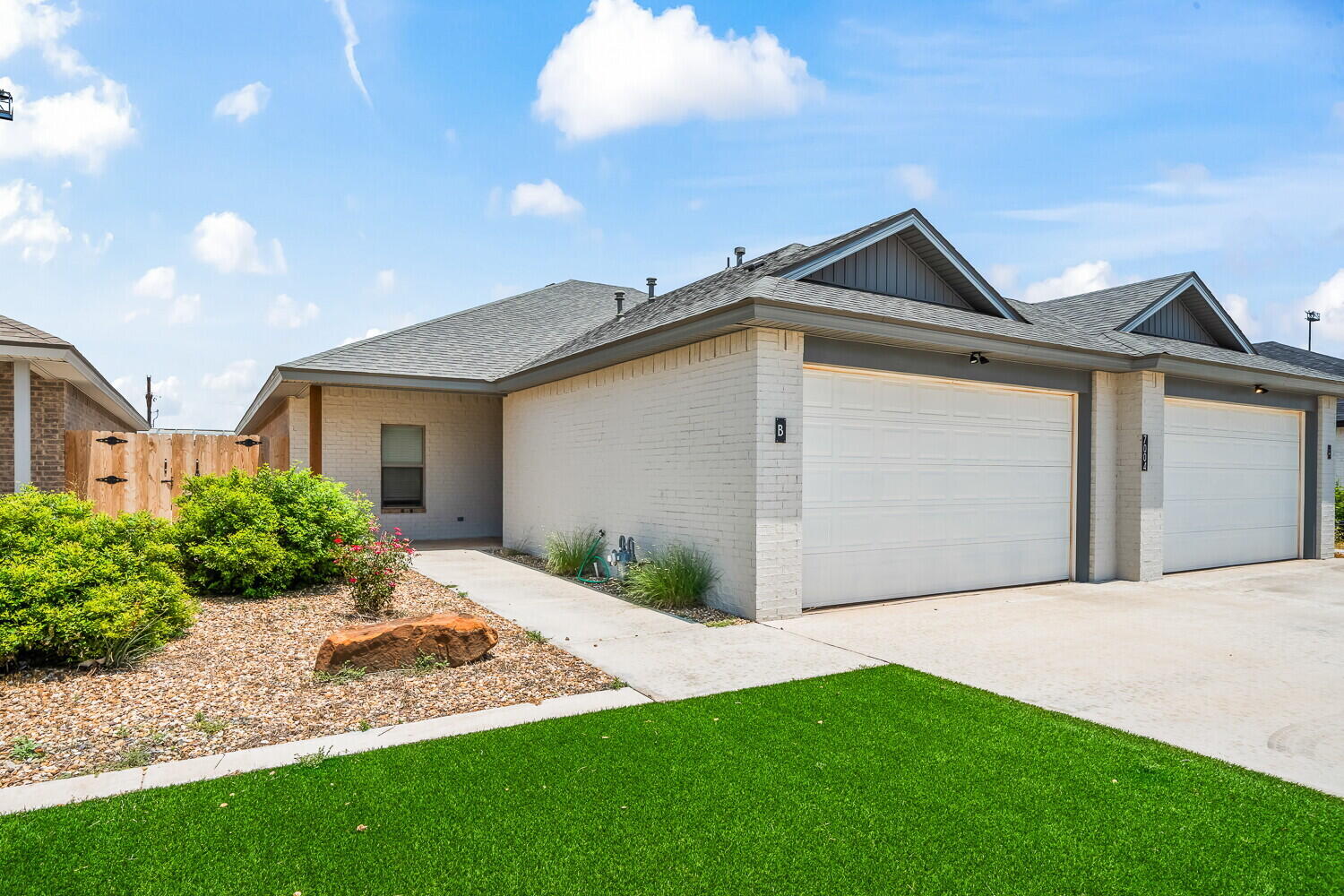 7010 40th Street, Unit A Lubbock, TX 79407 - Photo 2 of 21 a front view of a house with a yard and garage