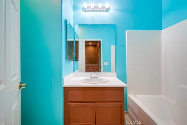a bathroom with a sink vanity tub and a mirror