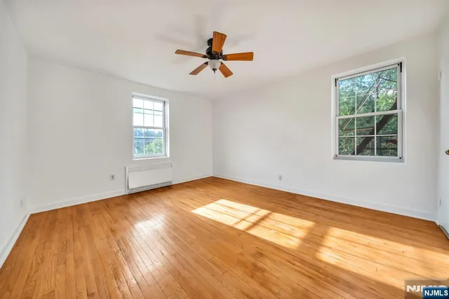 a view of empty room with wooden floor