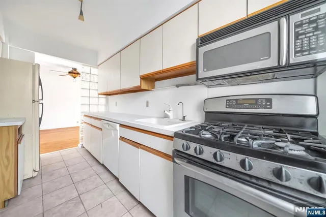 a kitchen with a sink a stove cabinets and a window