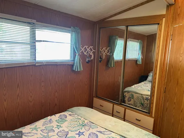 a bedroom with a bed tv and a window